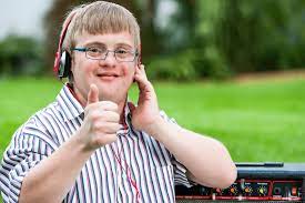 A young man wearing headphones giving a thumbs up